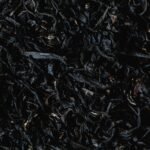 Detailed close-up of organic dried tea leaves showcasing texture and natural patterns.