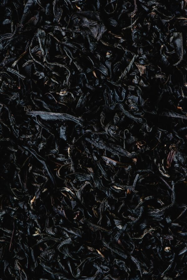 Detailed close-up of organic dried tea leaves showcasing texture and natural patterns.